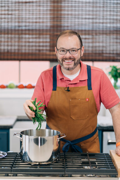 Stacey dropping green beans into pot.