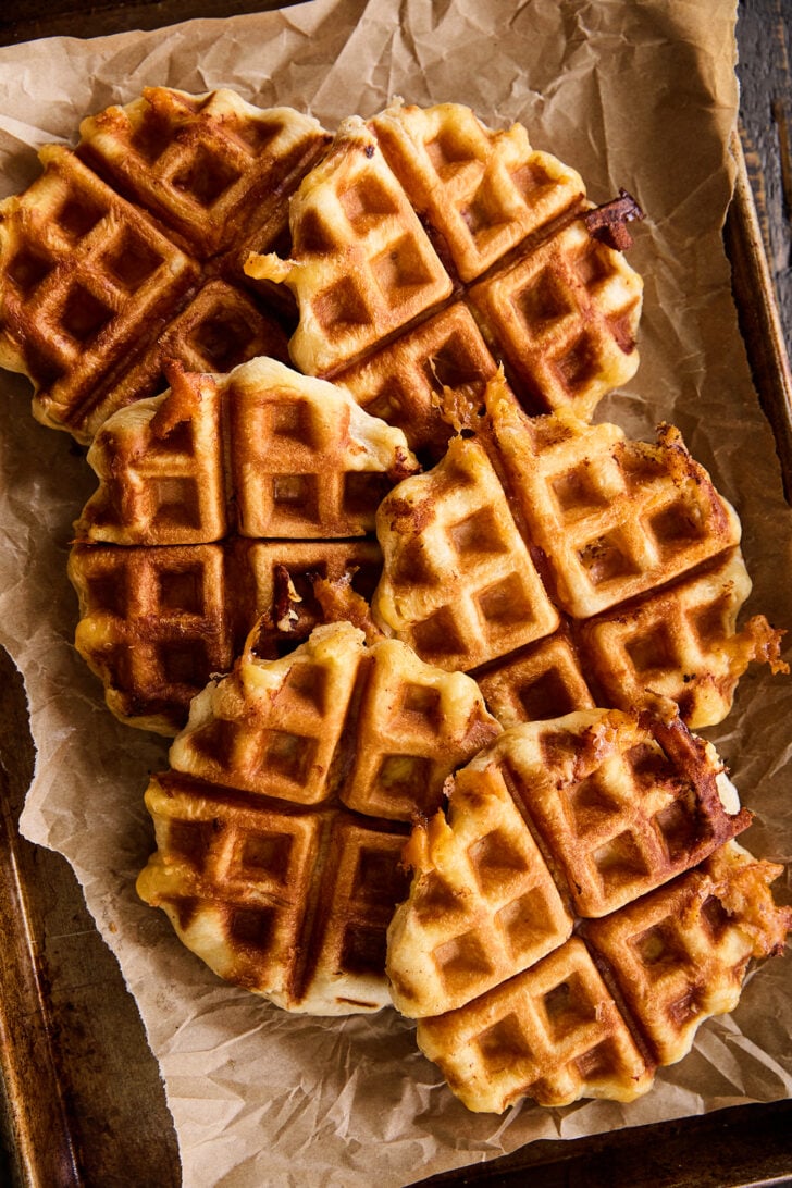 Ham, Egg, and Cheese Biscuit Wafflewiches on parchment paper.