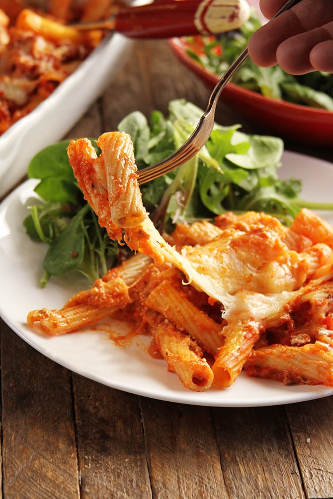 Formaggio Ziti al forno in piatto bianco con insalata