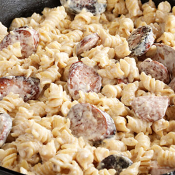 Weeknight Sausage Alfredo served in cast iron skillet