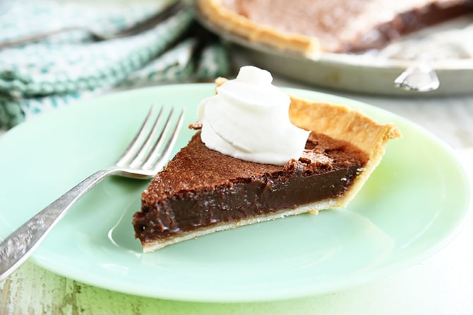 Chocolate Chess Pie served in plate with whipped topping.