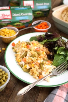 Family Favorite Chicken Noodle Casserole served on plate with canned vegetables in background