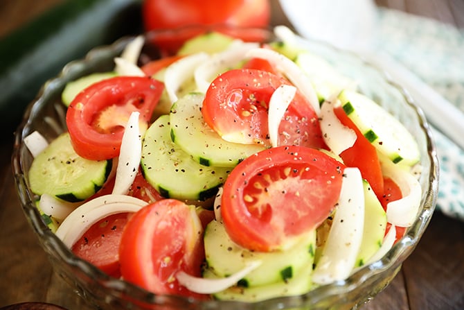 Tomto-, Komkommer-, en Uiensalade in een doorzichtige schaal