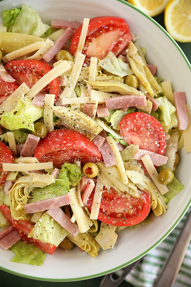 Salad with tomatoes, ham, olives, artichokes, and cheese.