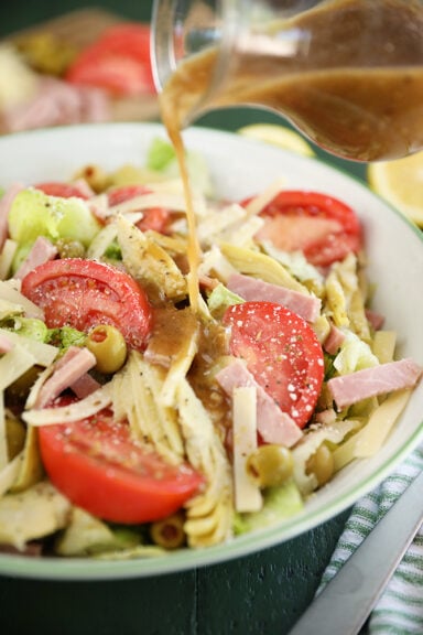 Salad with tomatoes, ham, olives, artichokes, and cheese.
