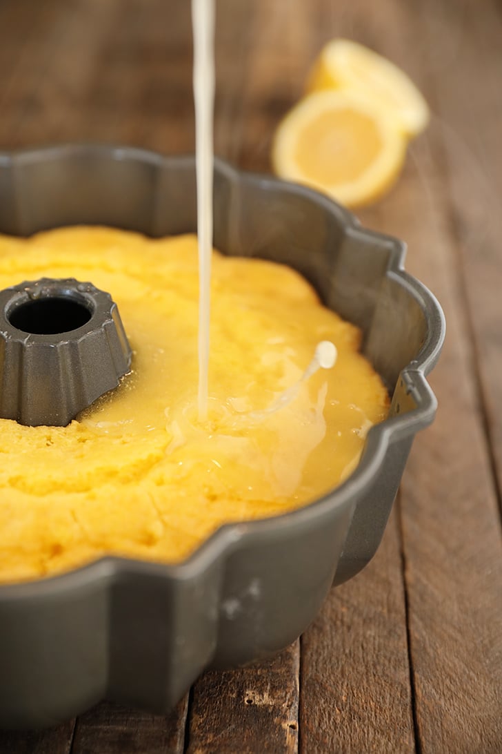 Lemonade glaze being poured over lemonade cake.