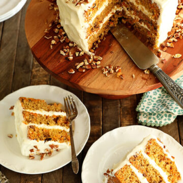 Carrot cake with slices missing and slices of cake on several plates.