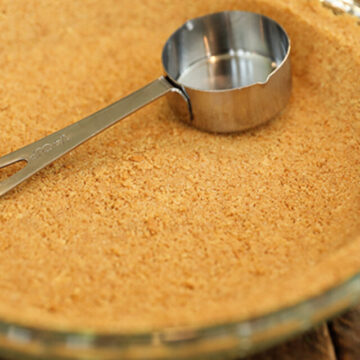 Graham cracker crust with measuring cup.
