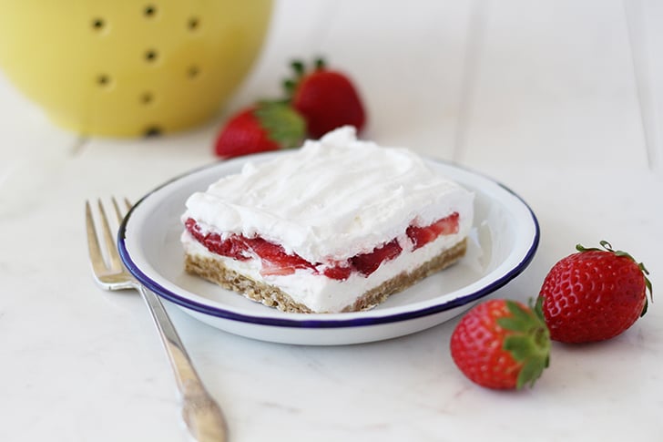 Slice of Strawberry Delight on plate with blue rim.