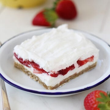 Slice of Strawberry Delight on plate with blue rim.