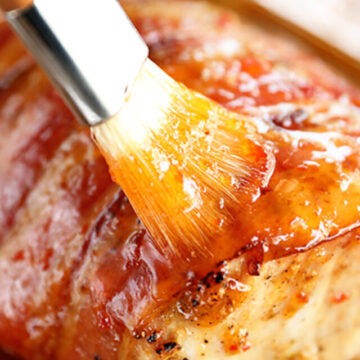 Brushing pepper jelly glaze on pork loin.
