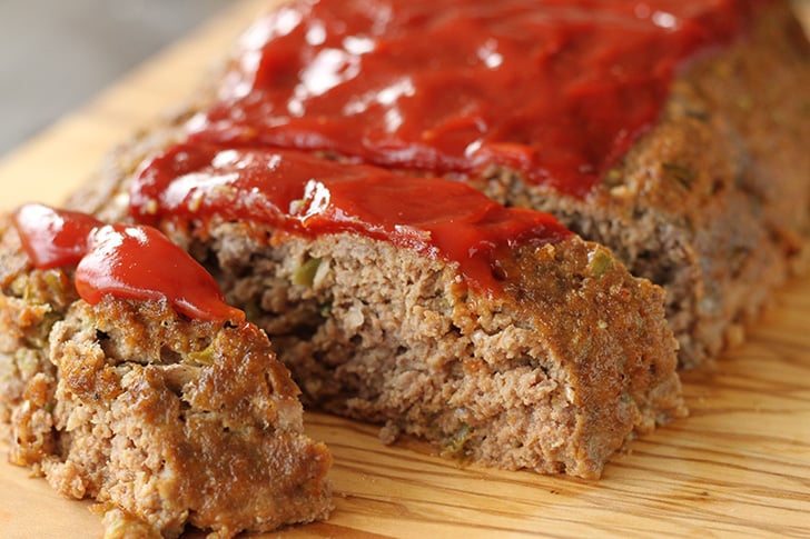 Sliced meatloaf on a cutting board.