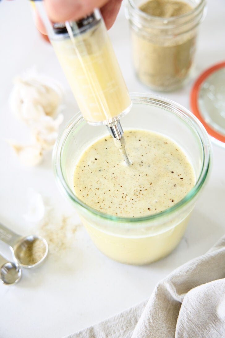 Filling a turkey injector with marinade.