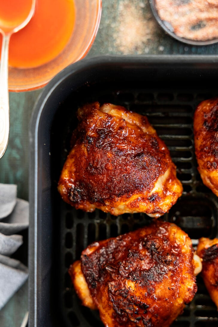 Chicken thighs in an air fryer with hot honey glaze.