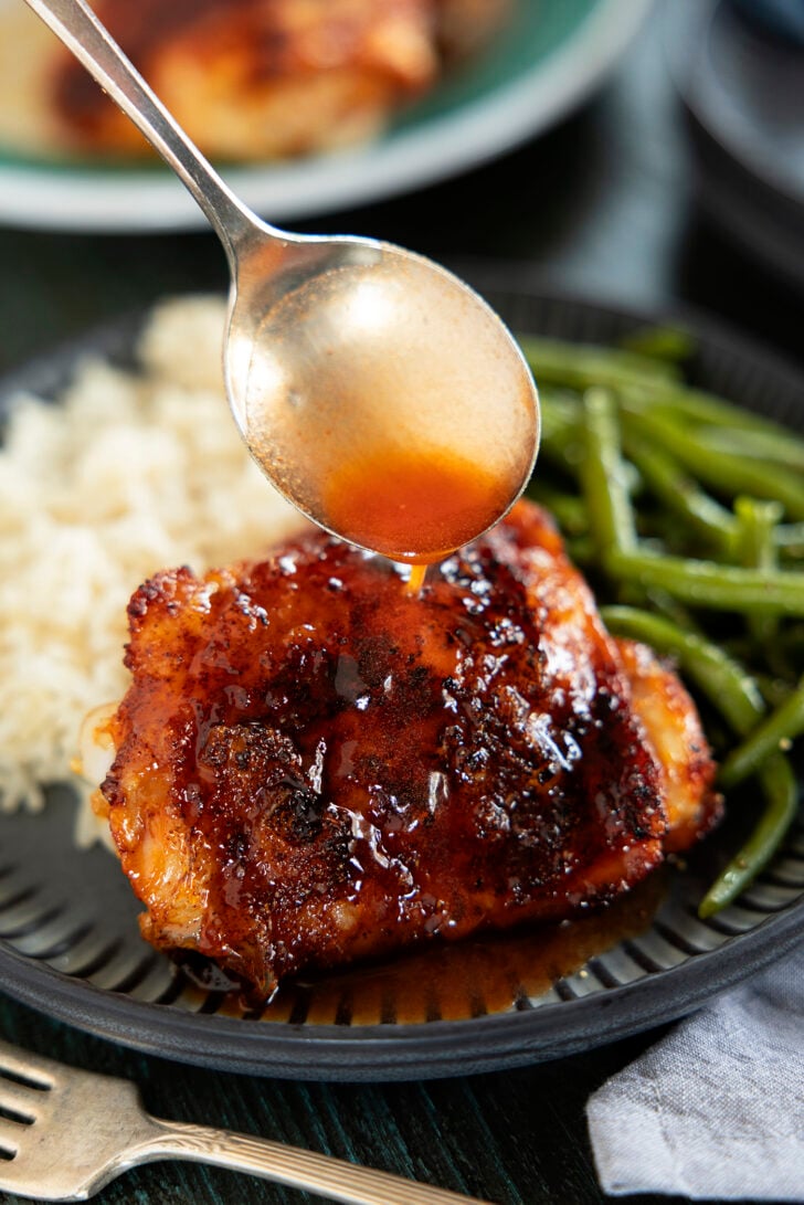 Air fryer chicken thigh on a plate with hot honey glaze.