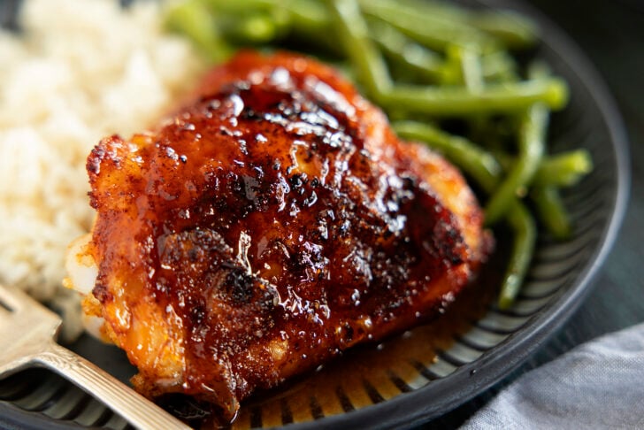 Air fryer chicken thigh on a plate with hot honey glaze.