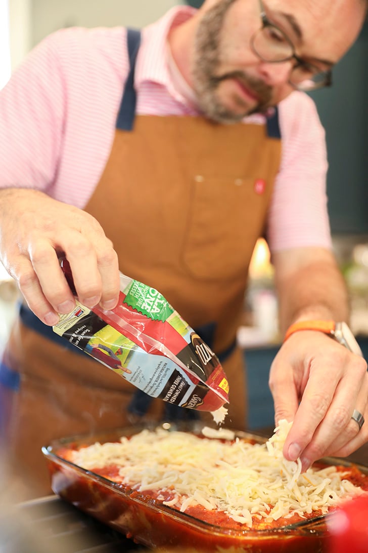 Stacey putting cheese on casserole.