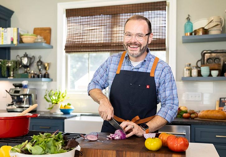 Stacey Little cutting vegetables on cutting board in kitchen